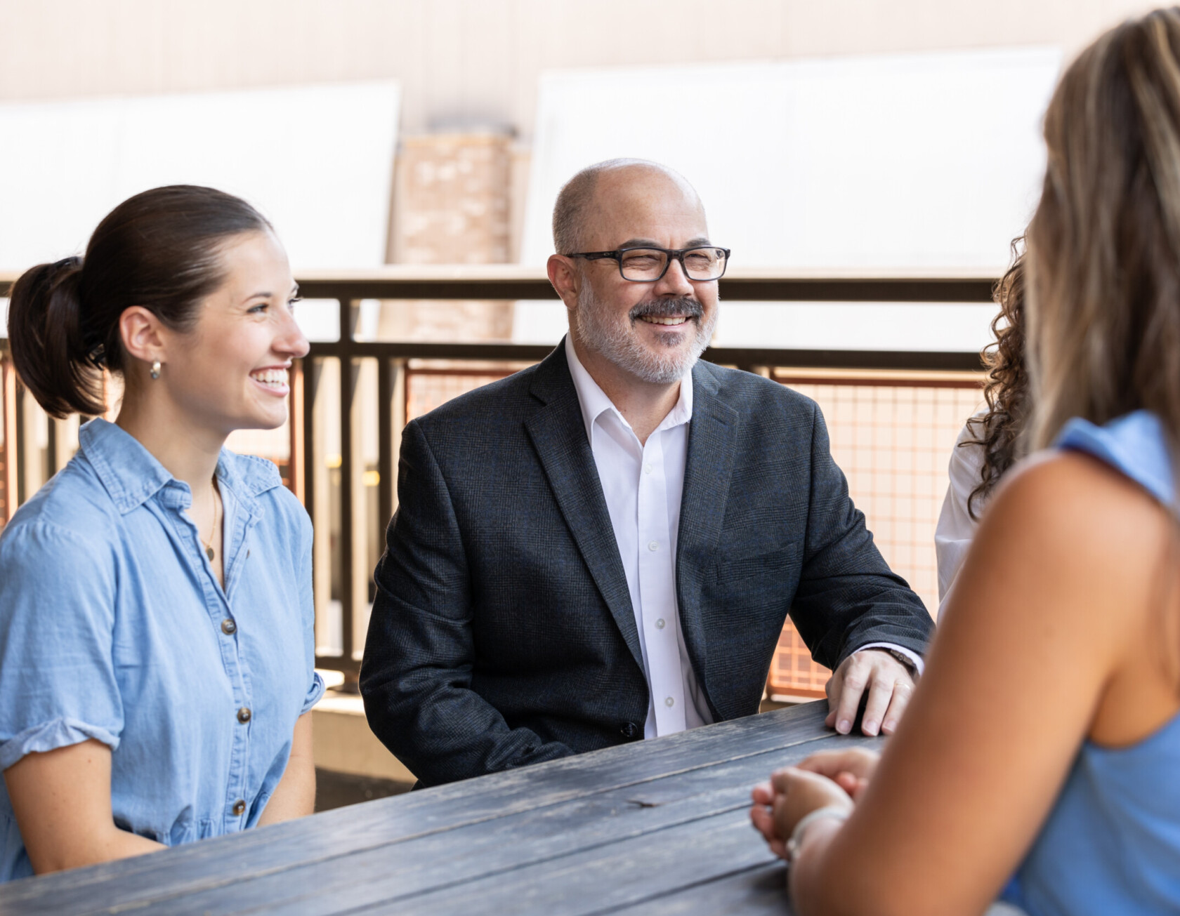 Group of ivision employees brainstorming together at a table outside.
